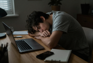 Person looking tired and unmotivated while working at a desk the morning after moderate alcohol consumption