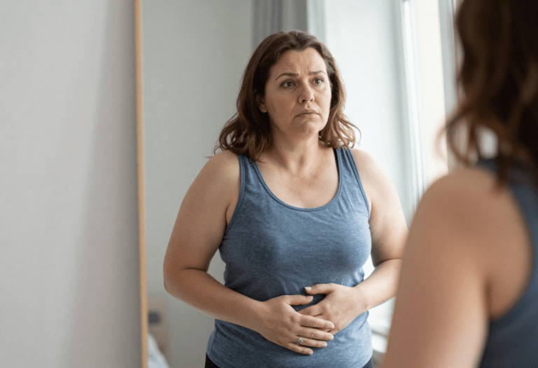 menopause belly fat woman holding stomach hormonal weight gain