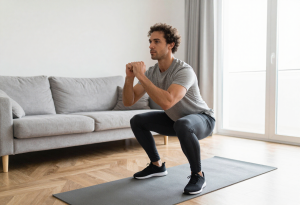 Man performing a home workout demonstrating consistent exercise over intensity.