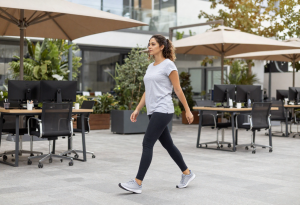 Woman taking a short walk outside during lunch or stretching at her desk, illustrating midday habits that support energy and wellness