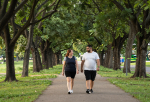 Slightly overweight midlife couple walking outdoors together, showing active lifestyle for sustainable weight management