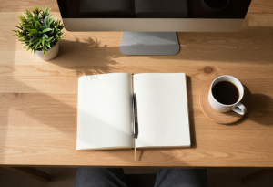 Cozy table with notebook, pen, and coffee, representing planning and small lifestyle changes