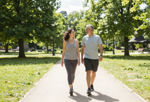 improve your mental health - adult walking outdoors in a park, casual fitness attire, relaxed and happy expression, lifestyle editorial style.