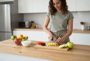 Attractive adult preparing healthy snacks like fruit, yogurt, and popcorn for weight management