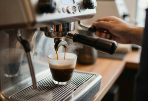 Barista preparing fresh coffee at an espresso machine.