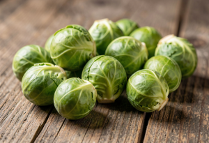 Fresh green Brussels sprouts on a wooden surface, showing texture and vibrant color for nutrition and gut health