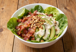 Salad with heavy toppings vs lighter salad to show high calories in healthy meals