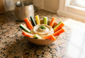 Hummus with vegetable sticks to show healthy dips that can be calorie dense