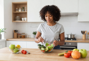“Person making a fresh salad, symbolizing attention to digestive health and mindful eating habits”