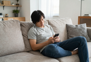 person looking tired while using phone showing subtle early signs of burnout