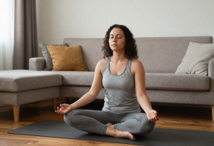 Woman practicing deep breathing at home to reduce stress and support healthy metabolism