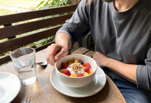 Adult eating fruit with yogurt and nuts to support balanced nutrition and stable blood sugar