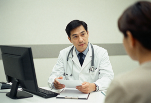 Doctor talking to a patient in a modern clinic, discussing blood pressure and heart health, realistic photo with warm and approachable atmosphere”