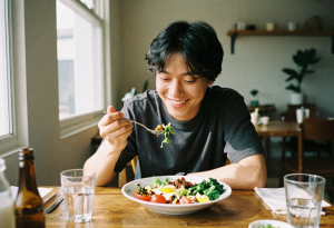 Happy person enjoying a healthy meal at a table, relaxed and smiling, illustrating successful acid reflux management