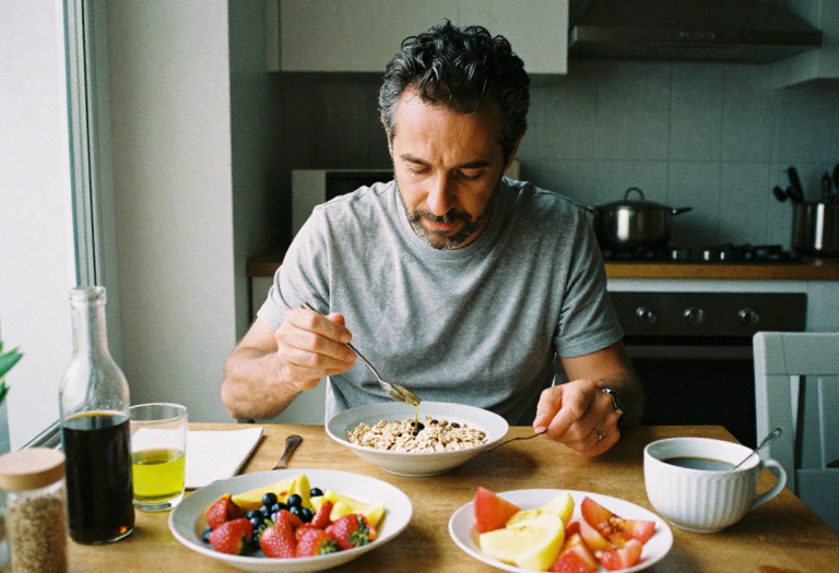 Man in kitchen considering healthy food choices related to cholesterol levels