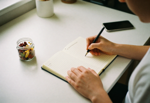 Writing in a food journal to identify sugar cravings and triggers