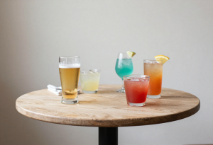 Glass of beer and a cocktail on a table, illustrating alcoholic drinks that can affect blood sugar in type 2 diabetes