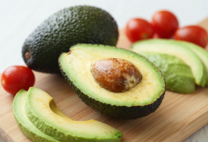 “Fresh avocado halves on a cutting board with slices and cherry tomatoes to support anxiety reduction and mood”