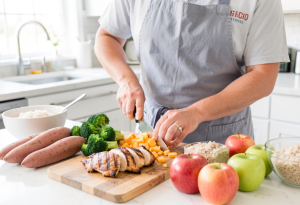 Person preparing a balanced meal with vegetables, protein, and grains to maintain healthy glucose levels