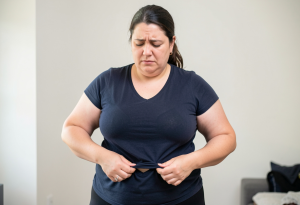 perimenopause symptoms - Woman noticing body changes during perimenopause.