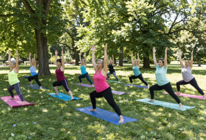 Wide-angle view of a group yoga class with women over 40, practicing gentle movement to support wellness during perimenopause symptoms