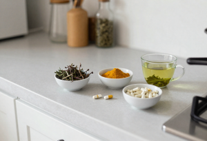 Bowls of liver-supporting herbs and supplements including milk thistle, turmeric, and green tea, illustrating supplements that can help support liver health naturally
