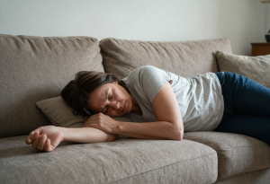 middle-aged person resting on couch looking fatigued, showing early liver stress