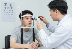 Middle-aged man having an eye exam with an optometrist, illustrating potential long-term effects of heavy alcohol consumption on vision and eye health